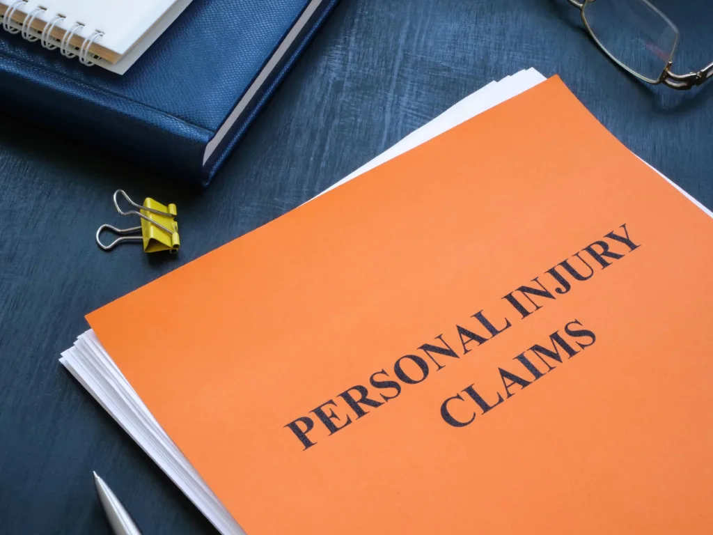 Personal injury claims file on office desk, representing legal case documentation and compensation process for accident victims. Personal injury claims file on office desk, representing legal case documentation and compensation process for accident victims.