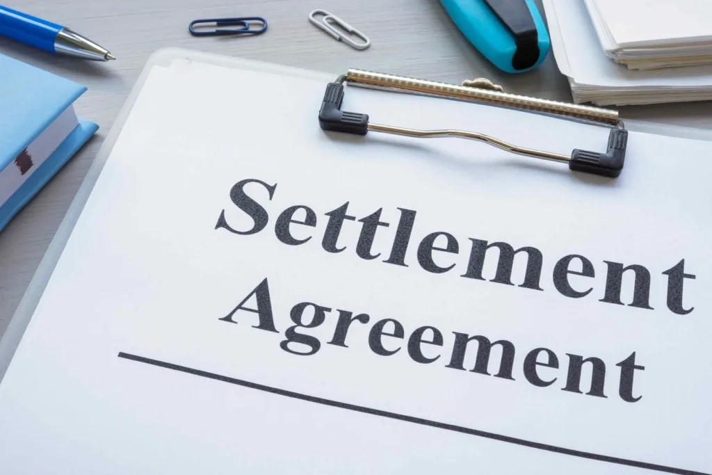 Settlement agreement document on clipboard, representing legal settlement, personal injury claim resolution, and compensation agreement.
