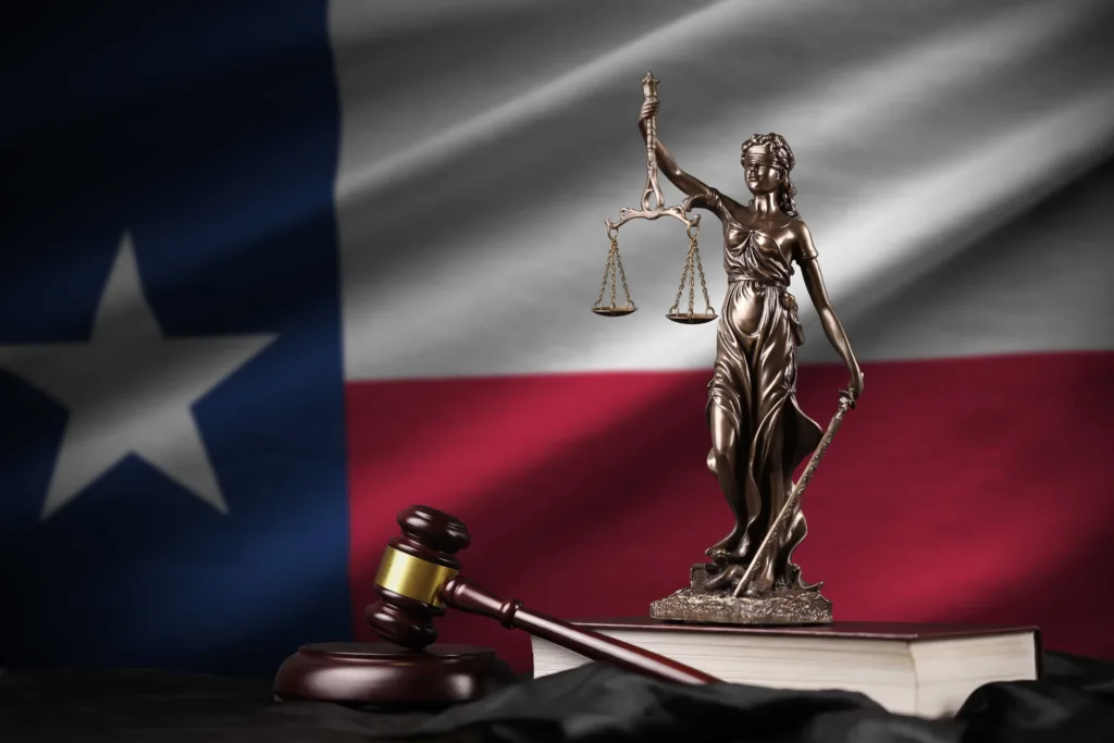 Lady Justice statue and judge’s gavel in front of Texas state flag, symbolizing Texas law, courts, and legal justice system.