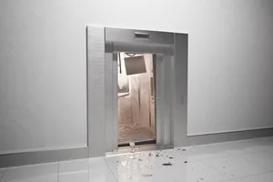 An up-close view reveals a modern elevator stuck open, its interior littered with debris, highlighted by a clearly visible malfunction sign, signaling danger.
