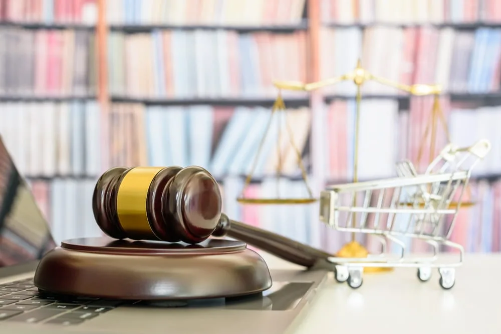 Legal symbols and shopping cart representing a product liability lawsuit involving a defective consumer product.